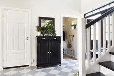 a black cabinet sitting in the middle of a living room next to a stair case