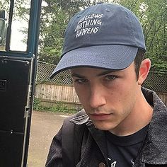 a young man wearing a blue hat with the words nothing happens written on it in white