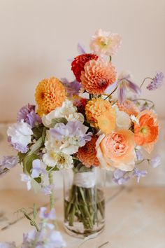 a vase filled with lots of different colored flowers