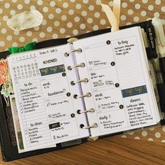 an open planner book sitting on top of a wooden table