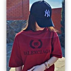 a woman wearing a baseball cap and red shirt with the word balenocia on it