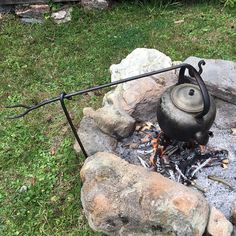 a kettle sitting on top of an open fire pit