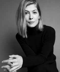 a black and white photo of a woman with her hands on her chest, posing for the camera