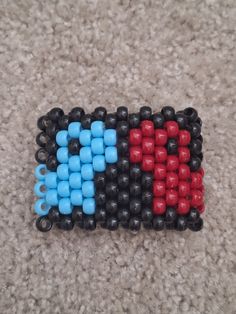 three pieces of colored beads sitting on top of a carpeted floor next to each other