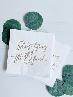 two napkins that say she's tying the knot on them with leaves around them