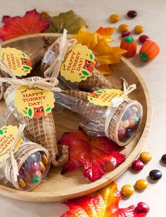 candies are wrapped in cellophane and placed on a plate with fall leaves