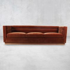 a brown couch sitting on top of a white floor