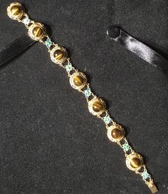 A very beautiful example of Chinese gold gilt on silver bracelet. This bracelet has bezel set round polished Tigereye stones With Enameling top and bottom and Flower links in between. Round tigereye cabochons measure 8mm with a Twist edge. There are 7 major links each set with Tigereye gold gilding all in tact . With 7 Alternate Enameled flower links . What a great gift for her absolutely near mint condition. Could become your family Heirloom . Get box with Purchase. Luxury Beads, Gems, And Cabochons For Formal Occasions, Luxury Gold Bracelets With Gemstone Accents, Gold Jewelry With Gemstone Accents In Oval Cabochon, Exquisite Gold Oval Cabochon Jewelry, Luxury Jeweled Gold Bracelets, Gold Jewelry With Gemstone Accents And Oval Cabochon, Gold Jewelry With Gemstone Accents, Luxury Cabochon Round Stone Jewelry, Luxury Gold Gemstone Cabochons