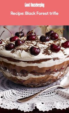 a cake with cherries and whipped cream on top is sitting on a doily