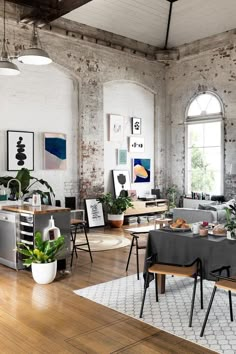 an industrial style living room with exposed brick walls and wood flooring is furnished with modern furniture