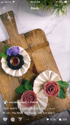 two paper flowers sitting on top of a wooden cutting board