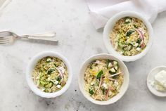 three white bowls filled with food next to silverware and spoons on a table