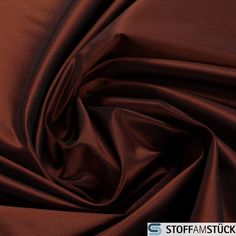 a close up shot of a dark brown satin fabric