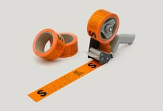 an orange tape dispenser and two rolls of scissors