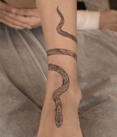 a woman's foot with a snake tattoo on it