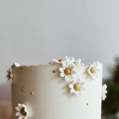 a close up of a white cake with flowers on the icing and gold sprinkles