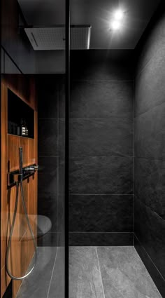 a black and white photo of a shower in a bathroom with wood paneling on the walls