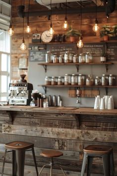 the interior of a coffee shop with several stools and lights hanging from the ceiling