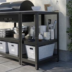 an outdoor bbq with two bins on the side and other containers underneath it