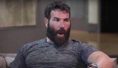 a man with a beard sitting on a couch