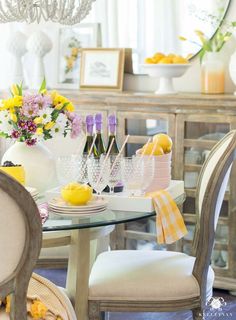 a dining room table with yellow and purple decorations on it, two wine glasses in front of the table