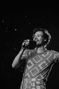 a man singing into a microphone on stage