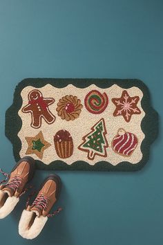 two pairs of shoes are on the floor next to a rug with various christmas decorations