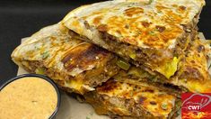 there are four quesadillas stacked on top of each other next to a bowl of dipping sauce