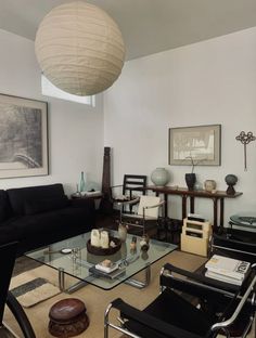 a living room filled with furniture and a large lamp hanging over the top of it