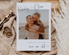 a couple is hugging and holding each other in front of their wedding photo on a blanket