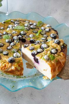 a blueberry cheesecake on a glass platter