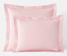 two pink pillows and one light pink pillow