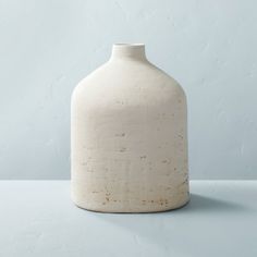 a white vase sitting on top of a table