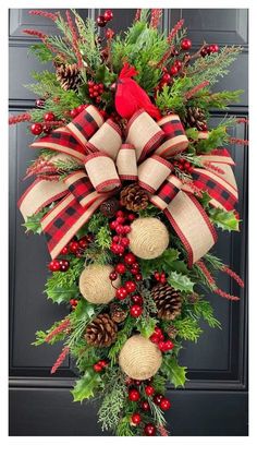 a christmas wreath with pine cones, berries and burlocks hanging from the front door