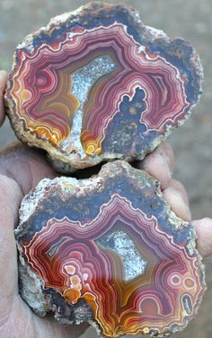 two colorful rocks are held in the palm of someone's hand with their fingers