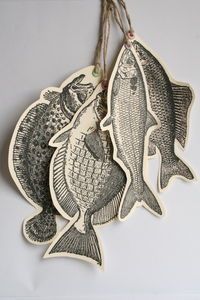 two fish hanging from strings on a wall