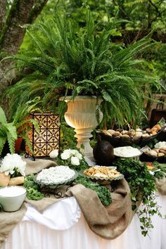 a table topped with lots of food and plants