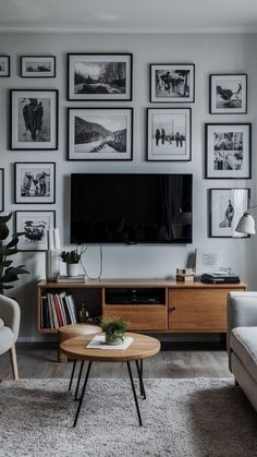 a living room filled with furniture and framed pictures on the wall above a flat screen tv