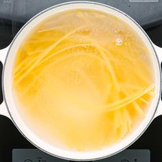 a pot filled with yellow liquid on top of a stove