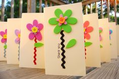 several cards with flowers on them sitting on a table