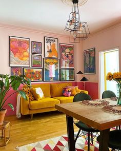 a living room filled with furniture and pictures on the wall above a wooden dining table