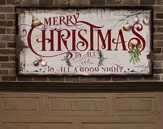 a merry christmas sign hanging on the side of a brick wall next to a garage door