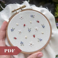 a hand is holding a small embroidery project