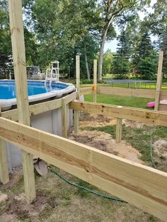 an above ground pool surrounded by wooden posts