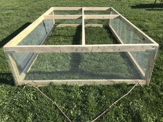 a chicken coop in the middle of some grass with chains attached to it's sides