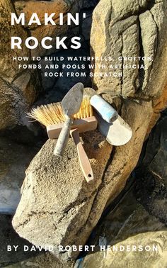 a rock with a brush and shovel on it sitting on top of a pile of rocks