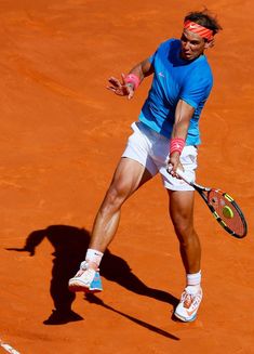 a man holding a tennis racquet on top of a tennis court