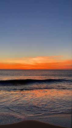 an orange and blue sunset over the ocean