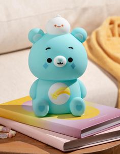 a small blue bear sitting on top of a book