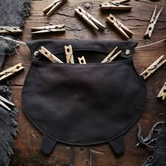 several pairs of scissors are in a black pouch on a wooden table with other woodworking tools